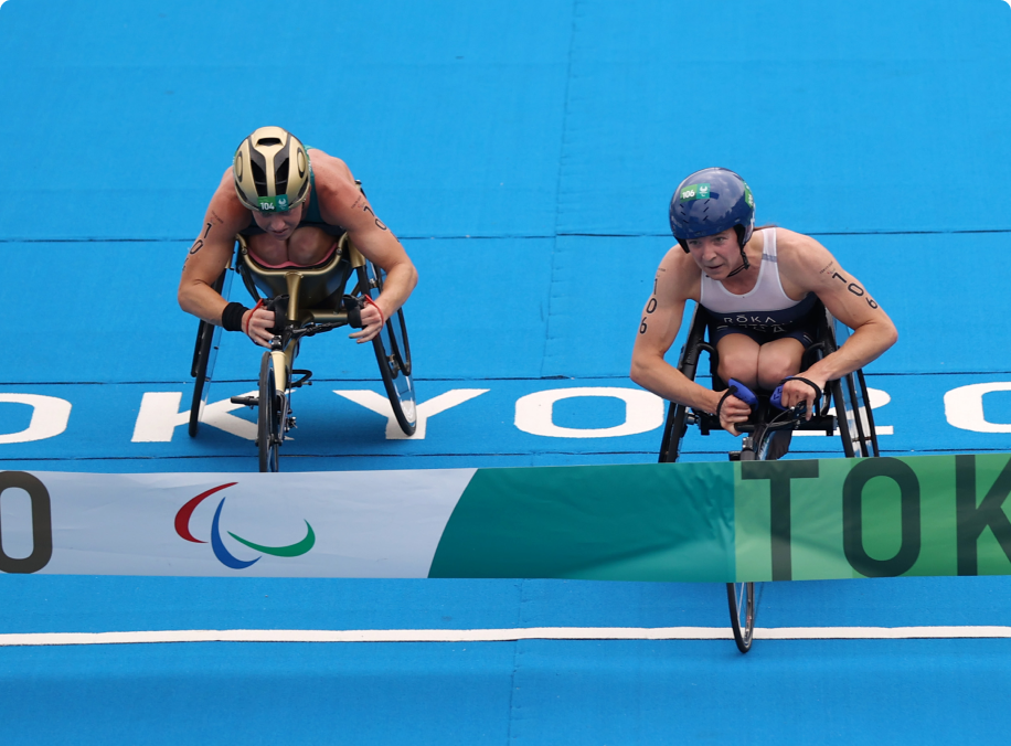 Gold medalist Kendall Gretsch and silver medalist Lauren Parker of Team Australia cross the finish line during the women's PTWC Triathlon at the Tokyo 2020 Paralympic Games.