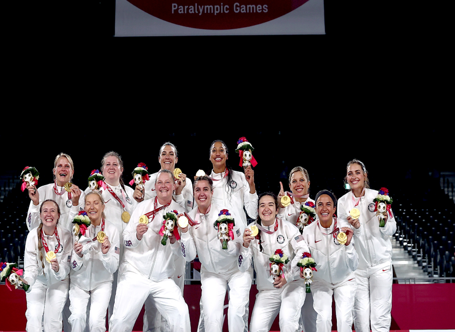 The Women's Sitting Volleyball team hold up their gold medals at the medal ceremony at the Tokyo 2020 Paralympic Games.
