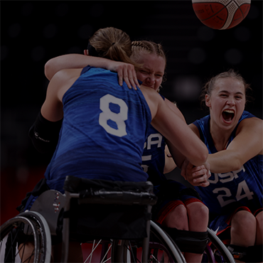 Women's wheelchair basketball team members celebrate at the Tokyo 2020 Paralympic Games.